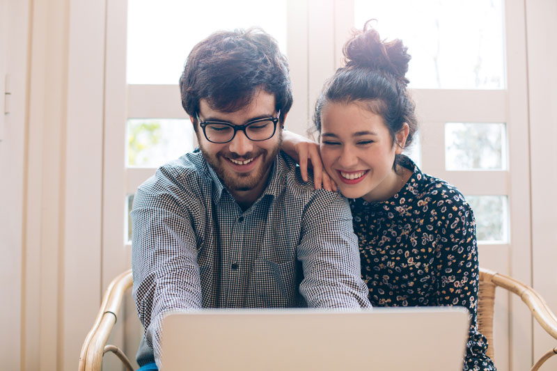 young couple looking at a laptop