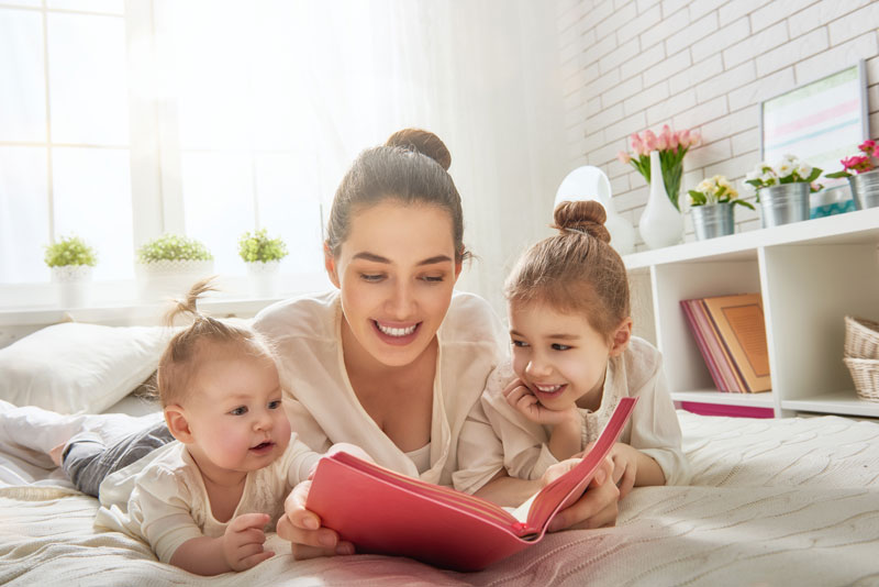 a mother and children reading a book