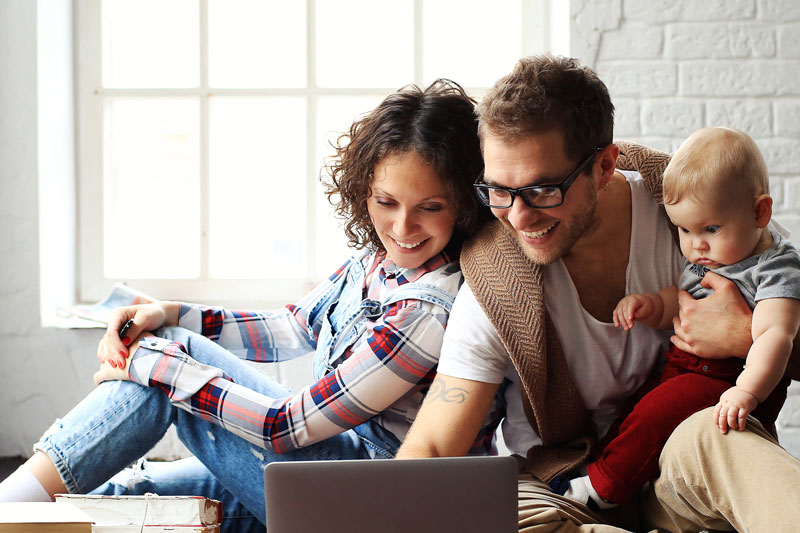 a family looking at a laptop and smiling