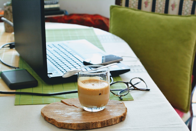 a laptop and coffee on a home desk
